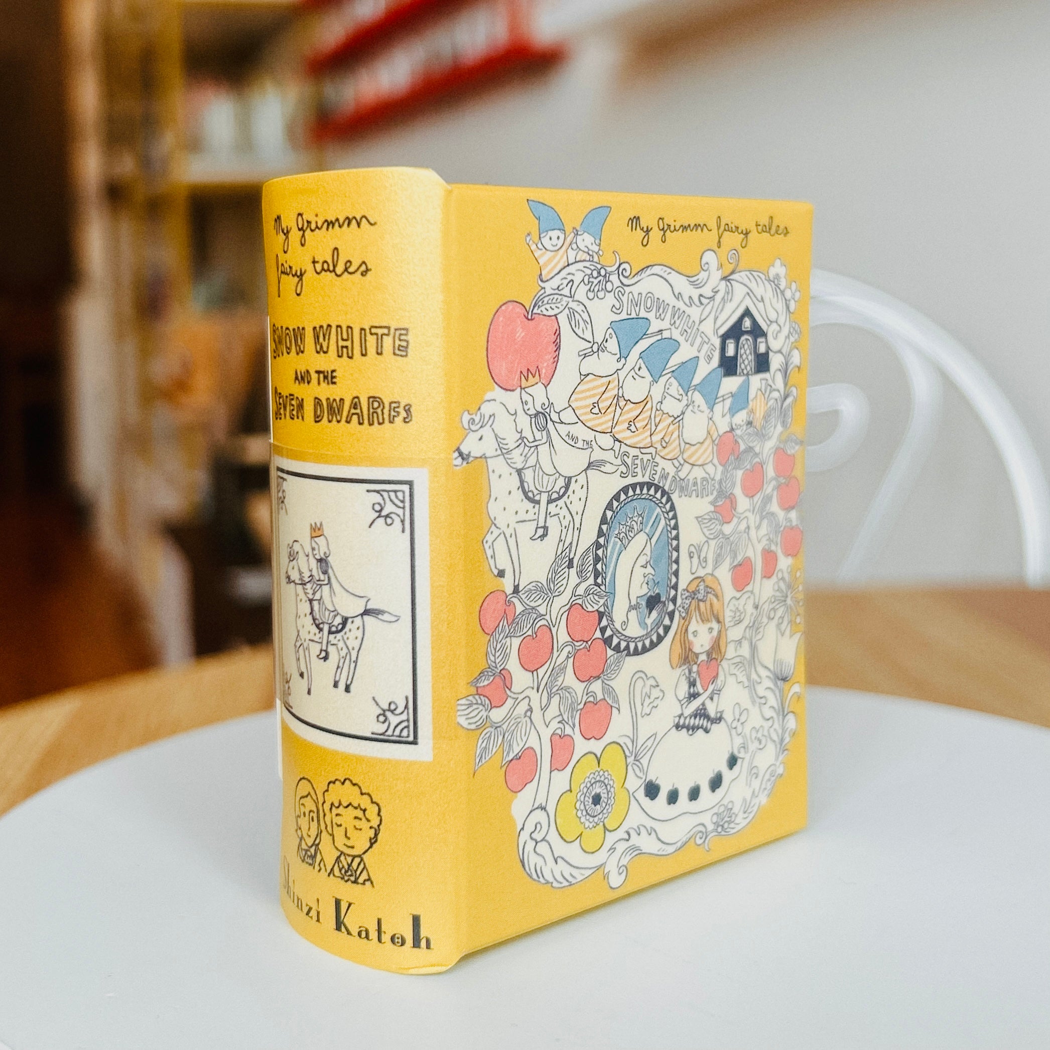 Book style case titled 'Snow White and the Seven Dwarfs' with colorful illustrations on a white surface.